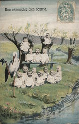 Multiple Babies sitting next to a Stork and a stream Postcard Postcard Postcard