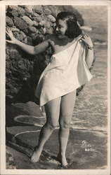 Woman covering herself in a towl by an ocean rock Swimsuits & Pinup Postcard Postcard Postcard