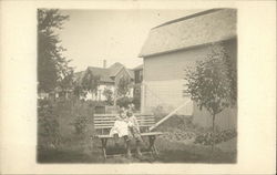 Two Children Hugging on a Bench Two Children Hugging on a Bench