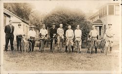 Ten Men - Nine Sitting on or Near Bicycles Postcard