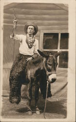 Man dressed as a Cowboy riding a Burro, Wooly Chaps Postcard