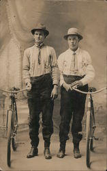 Two men posing with bicycles. Postcard