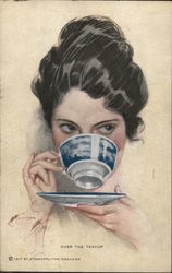 Over the Teacup - A woman looks up while drinking tea from a blue teacup Harrison Fisher Postcard Postcard Postcard