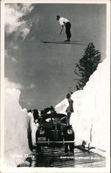 "Up and Over" Man Skiing over Models on Car Postcard