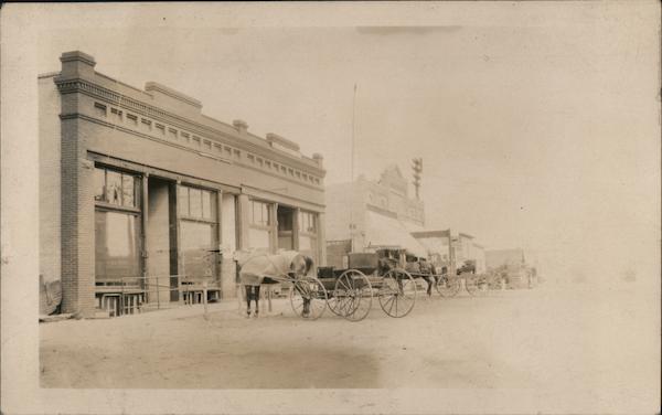 Horse drawn carriages in front of store front Harmony Minnesota