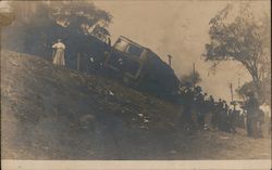 A train is pictured overturned on a hill Postcard