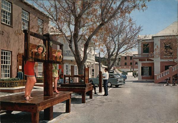 Sightseers have fun with the stocks in the Old Town, St. Georges Bermuda