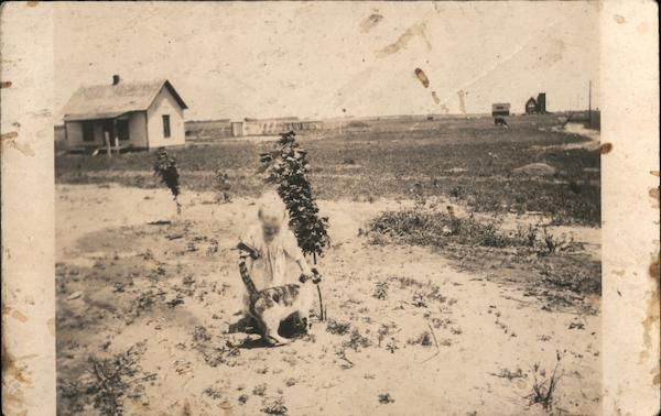 Girl and Cat In Front of House Built in 1914 Trousdale Kansas