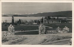 Gate entrance to park and lake, snow-capped mountains Postcard