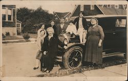 Family Sitting on Car in Residential Street Postcard