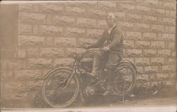 Man poses on early motorcycle with goggles pushed up onto forehead Postcard