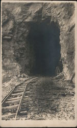 Railroad mine tracks lead into a dark hillside tunnel Trains, Railroad Postcard Postcard Postcard