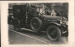 Early vehicle adorned with flowers Postcard