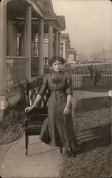 Woman Sitting on Chair in Yard in Front of Porch Postcard