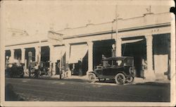 Model T cars are entering an old gasoline petrol station and mechanic service garage Original Photograph