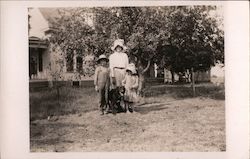 Three Children Wearing Hats in Yard Postcard