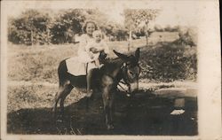 Young Girl and Toddler Sitting on a Donkey Postcard