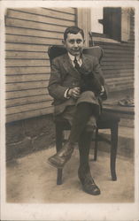 Young Man in Suit sitting on chair with Black Cat Postcard