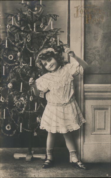 Little Girl Happily Posing in Front of Christmas Tree