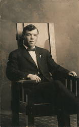 Young Man Sits in Arts & Crafts Style Chair Postcard