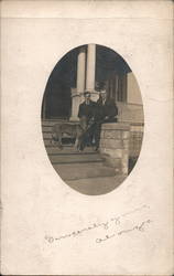 Two Men Sitting Outside on a Step with Their Dog Postcard