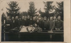 Group of people gathered around casket with flowers, Post-Mortem Postcard