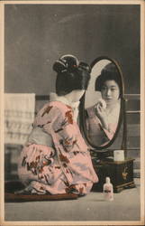 Geisha applying makeup in a mirror Postcard