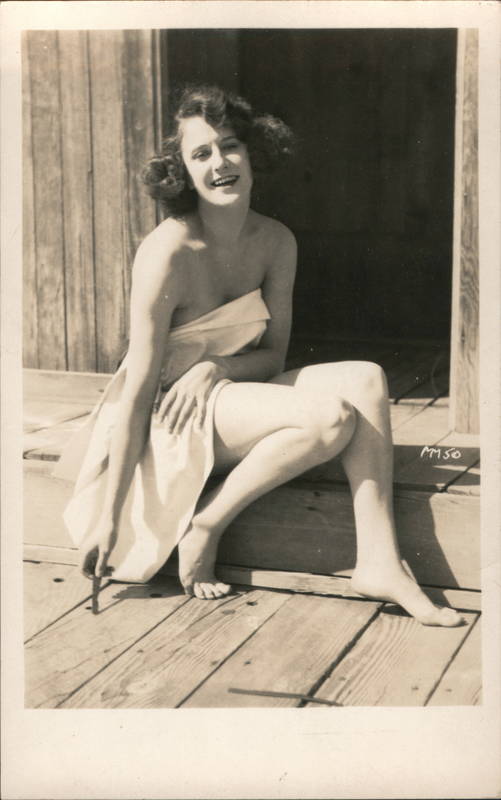 Flapper Lady sitting on a wooden porch covered with only a towel