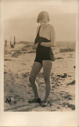 Woman on a beach taking off bathing suit Postcard