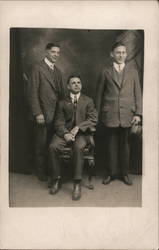 Three men pose Postcard