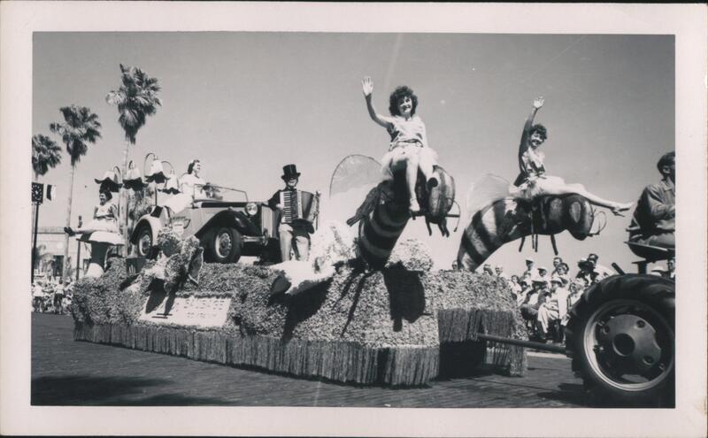 Float with women riding giant bees, accordion player, vintage car