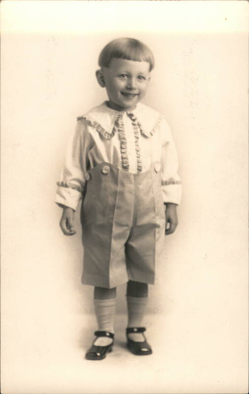 Smiling Boy in Ruffled Shirt and Suspender Shorts Children