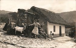 A woman, child and goat are pictured in front of a rustic home in Mexico Postcard Postcard Postcard