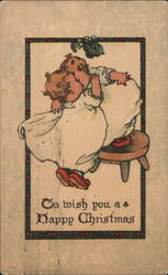 Two Children in Pajamas Kissing Under a Mistletoe Postcard