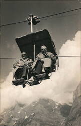 Two Men Riding Cable Car Over Mountains Postcard