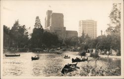 Canoeing on Lake, City Buildings in Background Postcard