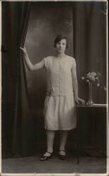 Woman in Flapper Dress with Curtain and Flowers Postcard