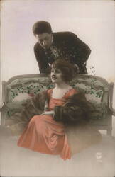 Couple in Romantic Pose on Ornate Sofa, Woman in Coral Dress Postcard