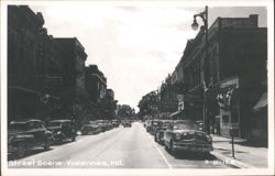 Downtown Street Scene with Vintage Cars and Businesses Postcard
