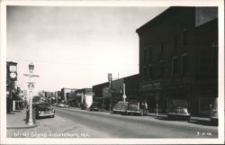 Street Scene with Vintage Cars, Bank and Storefronts Postcard
