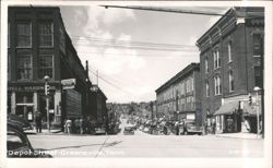 Downtown Street Scene with Shops, Cars, and Pedestrians Postcard