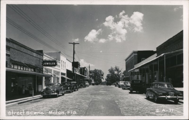Downtown Milton Street Scene with Parked Cars and Shops Florida