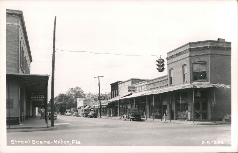 Downtown Street Scene with Shops, Cars, and Traffic Light Milton Florida