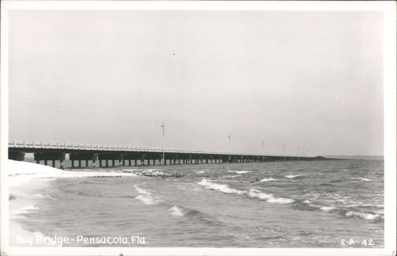 Bay Bridge over water with waves and sandy shore Pensacola Florida
