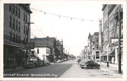 Downtown Street Scene with Vintage Cars, Businesses, and Pedestrians Postcard
