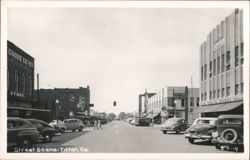 Downtown Street View with Shops, Vintage Cars, and Pedestrians Postcard