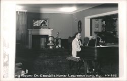 Man playing piano in Living Room, Dr. Caudill's Home Postcard