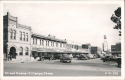 Downtown Street Scene with Businesses, Vintage Cars, and Water Tower Postcard