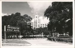 Edgewater Gulf Hotel with Road Sign and Lush Trees Postcard