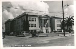 Central High School building facade with parked cars and palm tree Postcard